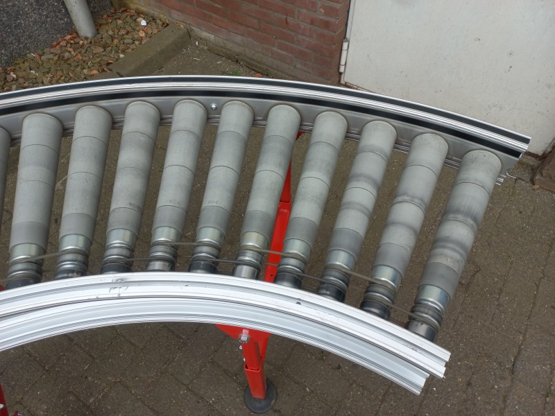 Aangedreven rollenbaanbocht met conische rollen, hoogte verstelbare ondersteuningen, dubbele zijgeleiding en snelheidsregeling op 230 volt