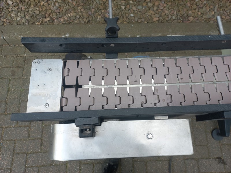 Aangedreven schakelband bocht 90 graden met RVS frame en snelheid geregelde motor op ondersteuningen
